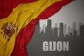 Abstract silhouette of the city with text Gijon near waving national flag of spain on a gray background