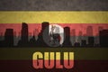 Abstract silhouette of the city with text Gulu at the vintage ugandan flag