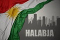 Abstract silhouette of the city with text Halabja near waving national flag of kurdistan on a gray background.3D illustration