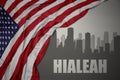 Abstract silhouette of the city with text Hialeah near waving national flag of united states of america on a gray background. 3D