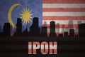Abstract silhouette of the city with text Ipoh at the vintage malaysian flag