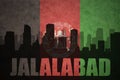 Abstract silhouette of the city with text Jalalabad at the vintage afghanistan flag