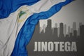 Abstract silhouette of the city with text Jinotega near waving national flag of nicaragua on a gray background. 3D illustration