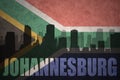 Abstract silhouette of the city with text Johannesburg at the vintage south africa flag