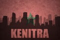 Abstract silhouette of the city with text Kenitra at the vintage moroccan flag