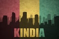 Abstract silhouette of the city with text Kindia at the vintage guinea flag