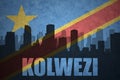 Abstract silhouette of the city with text Kolwezi at the vintage democratic republic of the congo flag