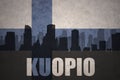 Abstract silhouette of the city with text Kuopio at the vintage finnish flag