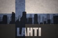 Abstract silhouette of the city with text Lahti at the vintage finnish flag