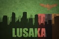 Abstract silhouette of the city with text Lusaka at the vintage zambian flag