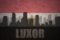 Abstract silhouette of the city with text Luxor at the vintage egyptian flag