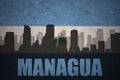Abstract silhouette of the city with text Managua at the vintage nicaraguan flag