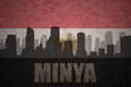 Abstract silhouette of the city with text Minya at the vintage egyptian flag