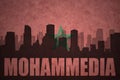 Abstract silhouette of the city with text Mohammedia at the vintage moroccan flag