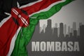 Abstract silhouette of the city with text Mombasa near waving colorful national flag of kenya on a gray background Royalty Free Stock Photo