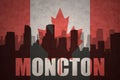 Abstract silhouette of the city with text Moncton at the vintage canadian flag