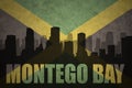 Abstract silhouette of the city with text Montego Bay at the vintage jamaican flag Royalty Free Stock Photo