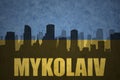 Abstract silhouette of the city with text Mykolaiv at the vintage ukrainian flag