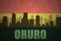 Abstract silhouette of the city with text Oruro at the vintage bolivian flag