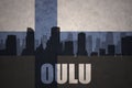 Abstract silhouette of the city with text Oulu at the vintage finnish flag