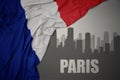 Abstract silhouette of the city with text Paris near waving national flag of france on a gray background Royalty Free Stock Photo