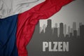 Abstract silhouette of the city with text Plzen near waving national flag of czech republic on a gray background