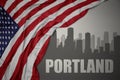 Abstract silhouette of the city with text Portland near waving national flag of united states of america on a gray background