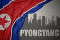 Abstract silhouette of the city with text Pyongyang near waving national flag of north korea on a gray background.3D illustration