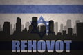 Abstract silhouette of the city with text Rehovot at the vintage israel flag