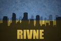 Abstract silhouette of the city with text Rivne at the vintage ukrainian flag