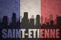 Abstract silhouette of the city with text Saint-Etienne at the vintage french flag