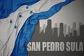 Abstract silhouette of the city with text San Pedro Sula near waving national flag of honduras on a gray background. 3D