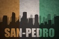 Abstract silhouette of the city with text San-Pedro at the vintage ivorian flag