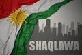 Abstract silhouette of the city with text Shaqlawa near waving national flag of kurdistan on a gray background.3D illustration
