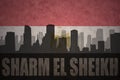 Abstract silhouette of the city with text Sharm El Sheikh at the vintage egyptian flag