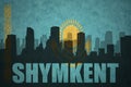 Abstract silhouette of the city with text Shymkent at the vintage kazakhstan flag