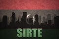 Abstract silhouette of the city with text Sirte at the vintage libyan flag Royalty Free Stock Photo
