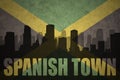 Abstract silhouette of the city with text Spanish Town at the vintage jamaican flag