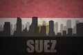 Abstract silhouette of the city with text Suez at the vintage egyptian flag