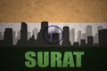 Abstract silhouette of the city with text Surat at the vintage indian flag