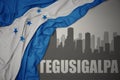 Abstract silhouette of the city with text Tegucigalpa near waving national flag of honduras on a gray background. 3D illustration