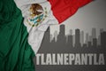 Abstract silhouette of the city with text Tlalnepantla near waving national flag of mexico on a gray background