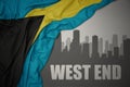 Abstract silhouette of the city with text West End near waving national flag of bahamas on a gray background. 3D illustration Royalty Free Stock Photo