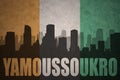 Abstract silhouette of the city with text Yamoussoukro at the vintage ivorian flag