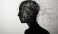 Abstract silhouette of a human head created from tangled black wire, representing complexity and emotion, set against a Royalty Free Stock Photo