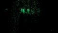 Abstract silhouette of male legs walking through the dark corridor with green glowing particles. Design. A man superhero