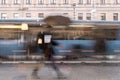 Abstract silhouette of man under umbrella, riding the bus, city street seen through raindrops on window glass, blurred Royalty Free Stock Photo