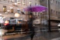 Abstract silhouette of people under umbrella, city traffic, urban street