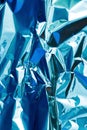 Abstract silver aluminum wrinkled foil multicolored background texture reflecting blue light. Silver crumpled foil Royalty Free Stock Photo