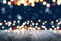 Abstract Snowy Christmas Background. Wooden Table With Defocused Lights Royalty Free Stock Photo